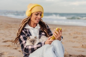 woman on the beach looking at a cell phone