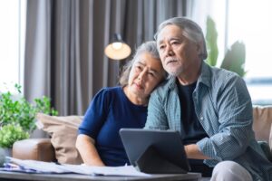 older couple lookin at their laptop and looking unhappy